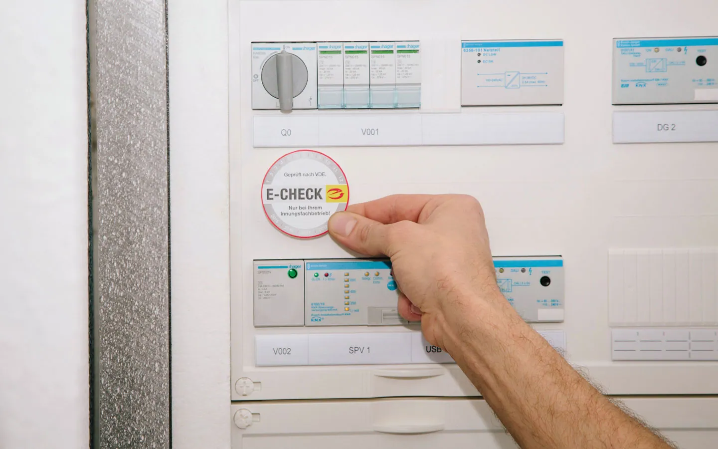 E-CHECK - Mitarbeiter klebt in der Verteilung die E-CHECK Plakette an &middot; Elektro-Adam-Mühlheim