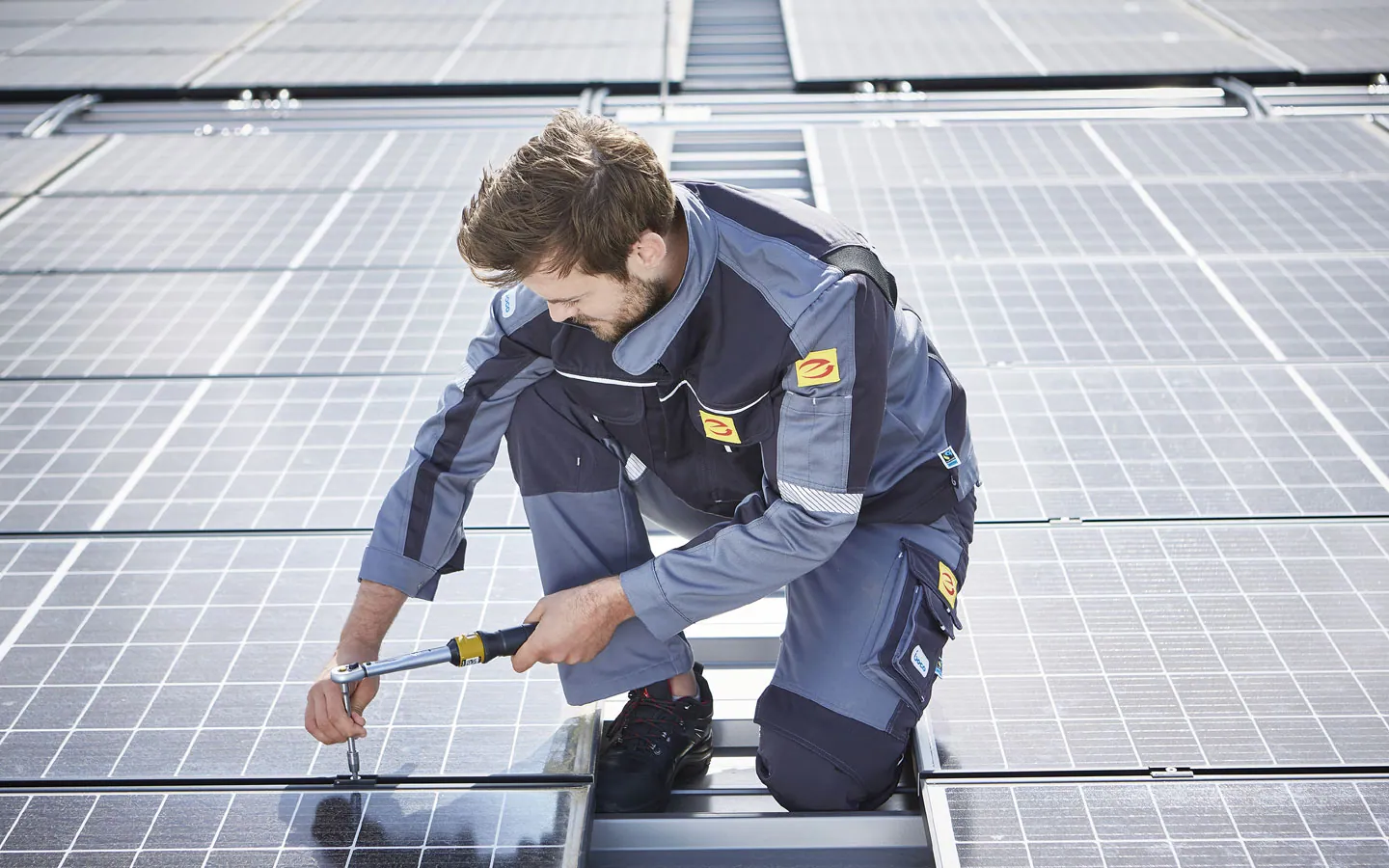 E-CHECK E-Mobilität - Mitarbeiter montiert auf dem Dach die neuen Solarmodule &middot; Elektro-Adam-Mühlheim